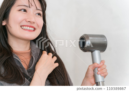 女人用吹風機吹乾頭髮（護髮） 110389867