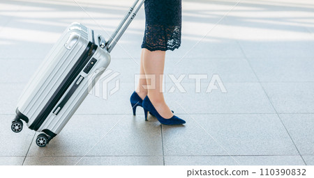 The feet of a business woman on a business trip or return from a trip with a suitcase at the station 110390832