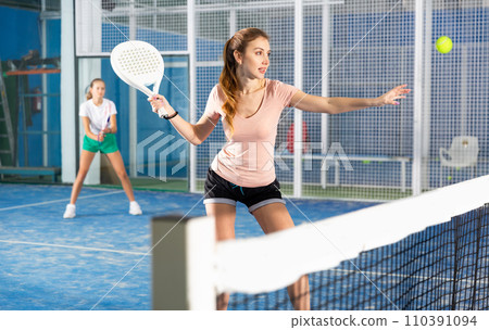 Woman playing padel in court 110391094