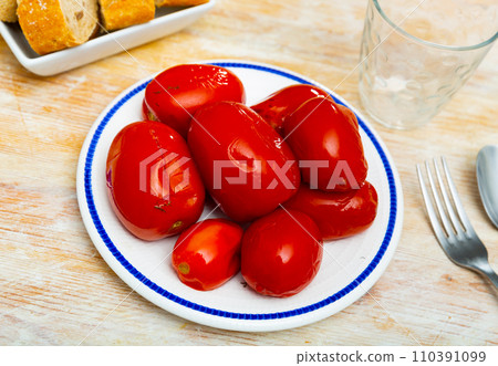 Plate with pickled tomatoes served for dinner on table 110391099