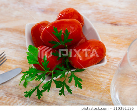 Marinated tomatoes garnished with fragrant fresh greens on plate Marinated tomatoes garnished with fragrant fresh greens on plate 110391156