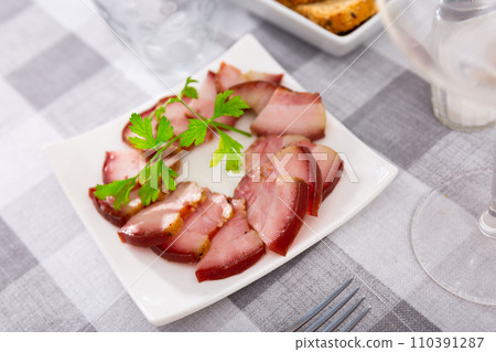 Delicious smoked lard, sliced with greens on white plate Delicious smoked lard, sliced with greens on white plate 110391287