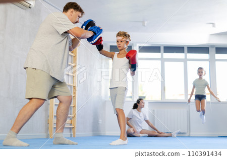 Father and son training boxing in studio 110391434