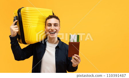 Happy young man travelling abroad, holding suitcase and passport 110391487