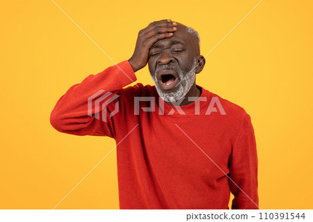 Distraught senior Black man with a white beard holding his head in his hand 110391544