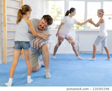 Father teaches his little daughter to use forceful techniques and grips during self defense classes 110391546