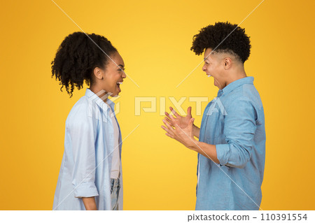 Angry young african american guy and woman in casual with open mouth, look at each other 110391554