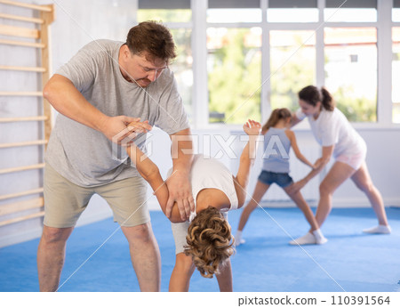 Father teaches his son to use forceful techniques and grips during self defense classes Father teaches his son to use forceful techniques and grips during self defense classes 110391564