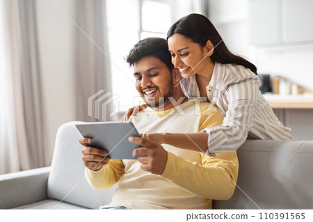 Young Happy Indian Spouses Using Digital Tablet At Home Young Happy Indian Spouses Using Digital Tablet At Home 110391565