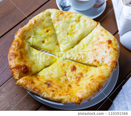 Sliced Megrelian khachapuri with melted suluguni cheese Sliced Megrelian khachapuri with melted suluguni cheese 110391566