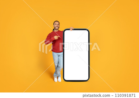 Positive guy hipster posing with big smartphone with empty screen Positive guy hipster posing with big smartphone with empty screen 110391871