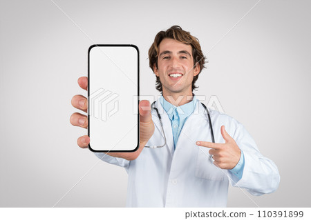 Doctor presenting and pointing at smartphone with blank screen Doctor presenting and pointing at smartphone with blank screen 110391899