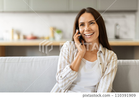 Beautiful young woman making phone conversation at home 110391909