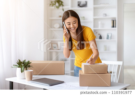 Asian Woman Checking Orders While Working At Home Office, 110391977