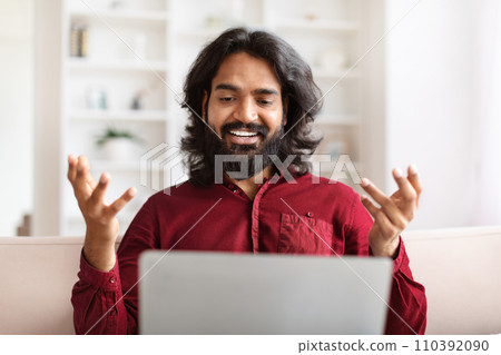 Portrait bearded young indian man have video call on laptop Portrait bearded young indian man have video call on laptop 110392090