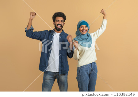 Joy Of Win. Happy Excited Muslim Couple Celebrating Success With Raised Fists 110392149