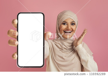 Mobile Offer. Excited Muslim Female In Hijab Showing Big Blank Smartphone Screen Mobile Offer. Excited Muslim Female In Hijab Showing Big Blank Smartphone Screen 110392289