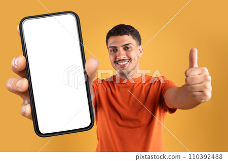 Cheerful brazilian man holding huge phone with white screen Cheerful brazilian man holding huge phone with white screen 110392488