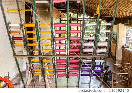 Cotton yarn spindles used for weaving on a traditional wooden handloom Cotton yarn spindles used for weaving on a traditional wooden handloom 110392540