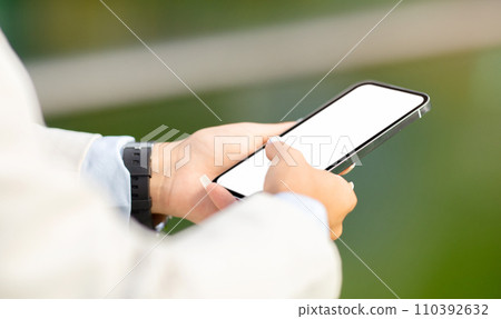Close-up of a professional's hands using a modern smartphone, with a focus on the screen Close-up of a professional's hands using a modern smartphone, with a focus on the screen 110392632