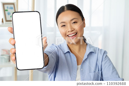 Asian woman holding phone with white blank screen 110392688