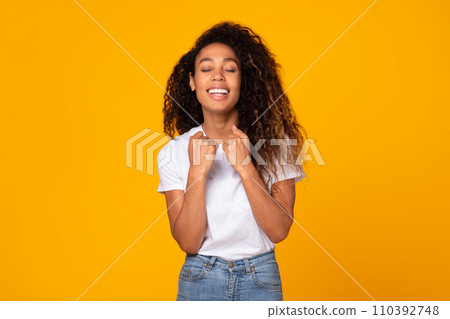 Curly young african american lady gesturing yes in celebration, studio 110392748