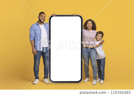 Happy Black Family Standing Near Big Smartphone With Blank Screen Happy Black Family Standing Near Big Smartphone With Blank Screen 110392885