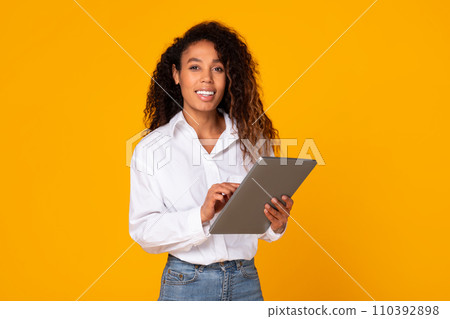 Cheerful African American lady engaging with digital tablet in studio 110392898