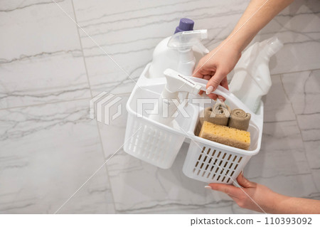 Female hands holding plastic container with chemical detergent for bathroom laundry cleaning 110393092