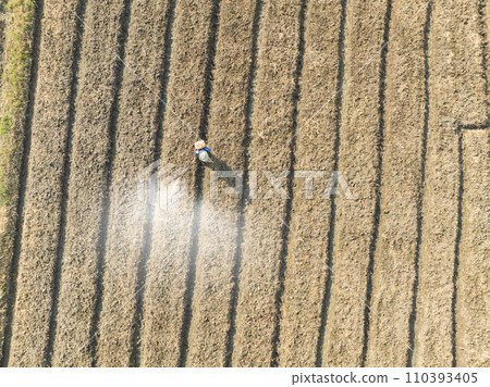 Farmer spraying pesticide on soy field. 110393405