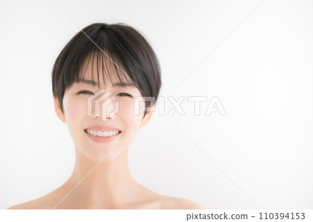 Close-up of a woman with beautiful bare skin smiling at the camera Close-up of a woman with beautiful bare skin smiling at the camera 110394153