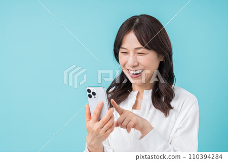 A middle-aged woman who operates a smartphone. A middle-aged woman who operates a smartphone. 110394284