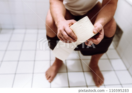 man sitting on toilet 110395283