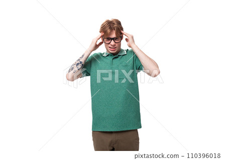 a young red-haired man dressed in a green T-shirt is trying to concentrate on his thoughts a young red-haired man dressed in a green T-shirt is trying to concentrate on his thoughts 110396018