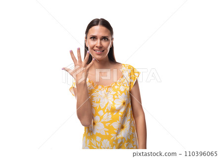 brunette young woman dressed in a summer yellow outfit shows high five with her finger brunette young woman dressed in a summer yellow outfit shows high five with her finger 110396065