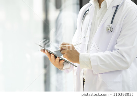 Close up of doctor hands using digital tablet at clinic. 110398035