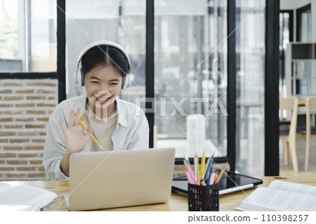 Young woman waving to his colleague and explaining and discuss her opinions during the online meeting. Young woman waving to his colleague and explaining and discuss her opinions during the online meeting. 110398257