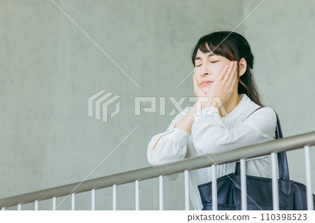 Business woman resting her chin on the handrail on the staircase landing 110398523