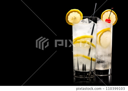 Set of classic Tom Collins or Whiskey sour cocktail with a maraschino cherry and lemon slice on black background Set of classic Tom Collins or Whiskey sour cocktail with a maraschino cherry and lemon slice on black background 110399103