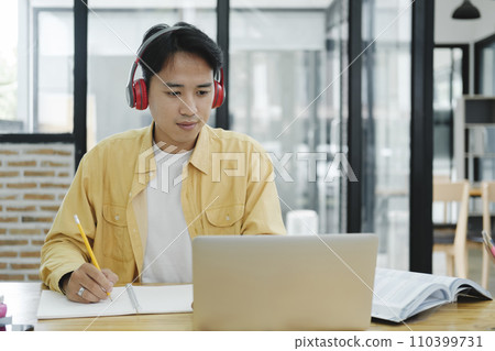 Young collage student using computer and mobile device studying online... 110399731