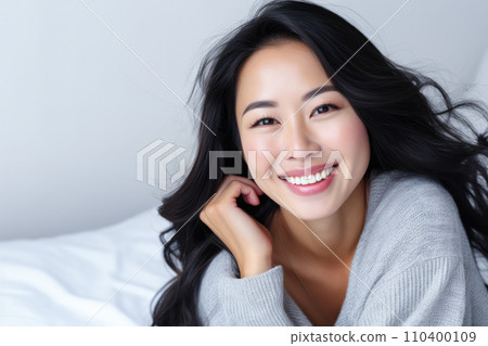 Smiling Asian woman at her home with a positive mood 110400109