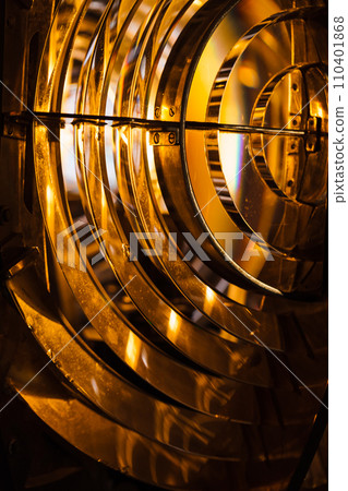 Close up vertical photo of a lighthouse lamp with Fresnel lens 110401868