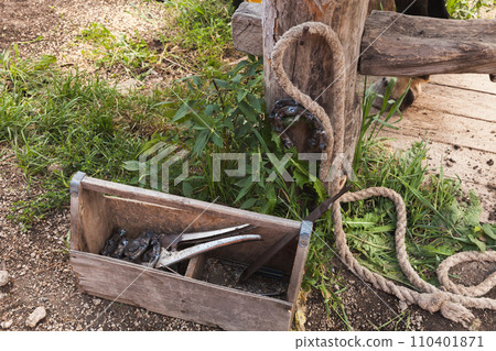 Horse shoeing tools lay in a wooden toolbox on a farm Horse shoeing tools lay in a wooden toolbox on a farm 110401871
