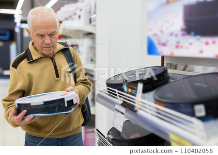 Elderly man choosing robot vacuum cleaner in showroom of electrical appliance store Elderly man choosing robot vacuum cleaner in showroom of electrical appliance store 110402058