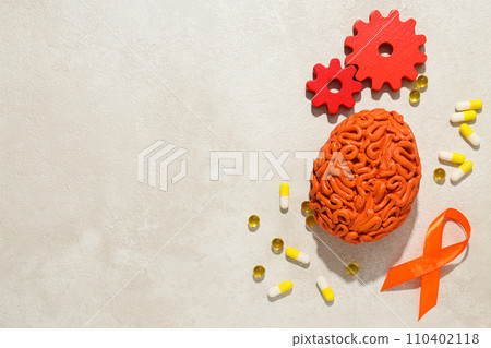 Orange human brain model with pills and gears Orange human brain model with pills and gears 110402118