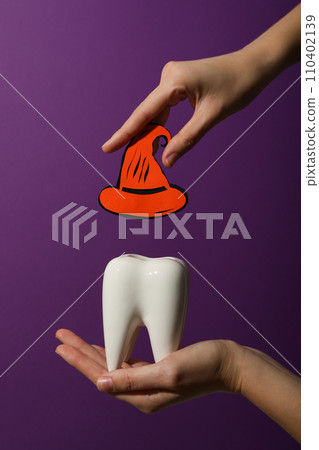 Big tooth with Halloween accessories, on a colored background. 110402139