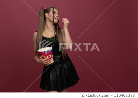 Portrait of impressed lady hand hold popcorn isolated on red color background Portrait of impressed lady hand hold popcorn isolated on red color background 110402358