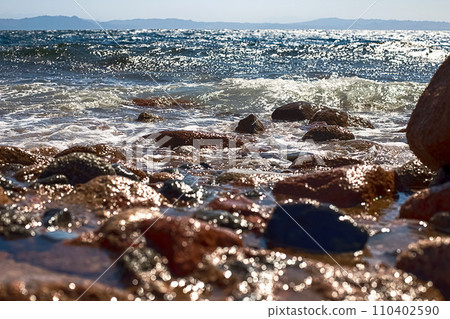View of the Red Sea shore, pebble beach and kami close-up. Leisure concentration. Egypt, Dahab View of the Red Sea shore, pebble beach and kami close-up. Leisure concentration. Egypt, Dahab 110402590