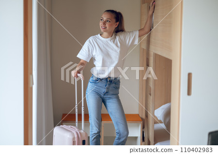 Cute trendy young girl with a suitcase Cute trendy young girl with a suitcase 110402983