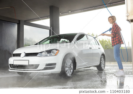 Woman washing the car and looking concentrated 110403180